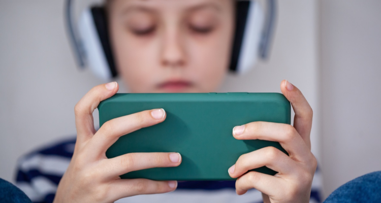 Niño usando celular con audifonos
